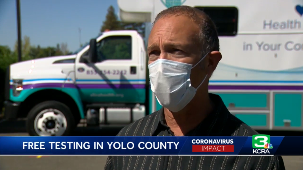 Man with mask in front of mobile clinic